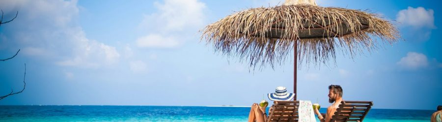 couple relaxing on tropical beach chairs